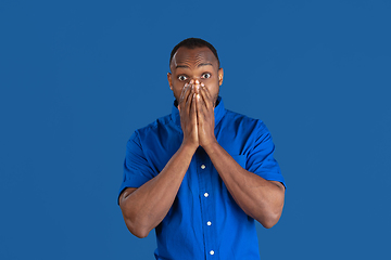 Image showing Monochrome portrait of young african-american man on blue studio background