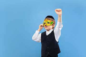 Image showing Portrait of a young orthodox jewish boy isolated on blue studio background, meeting the Passover