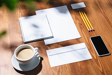 Image showing Creative and cozy workplace at home office, inspirational mock up with plant shadows on table surface