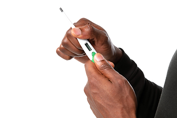 Image showing How coronavirus changed our lives. Close up of male hands holding thermometer, taking temperature on white background