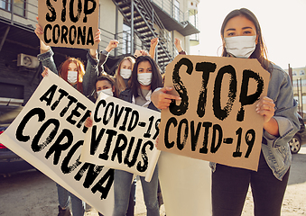 Image showing Young people in face masks protesting of stop coronavirus pandemic on the street