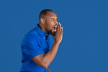 Image showing Monochrome portrait of young african-american man on blue studio background