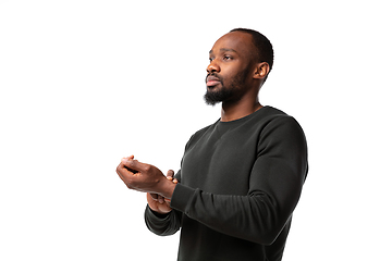 Image showing How coronavirus changed our lives. Young man taking pulse on white background