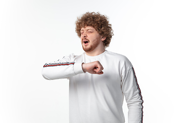 Image showing How coronavirus changed our lives. Young man sneezing on white background