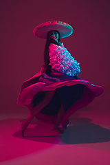 Image showing Fabulous Cinco de Mayo female dancer on purple studio background in neon light