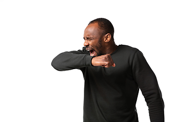 Image showing How coronavirus changed our lives. Young man sneezing on white background