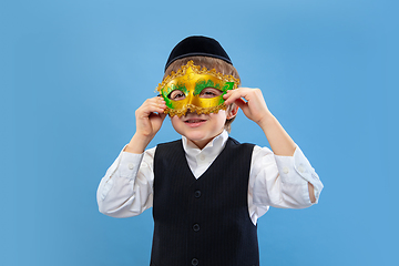 Image showing Portrait of a young orthodox jewish boy isolated on blue studio background, meeting the Passover