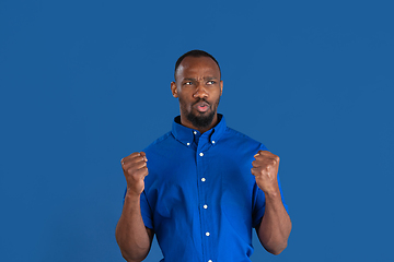 Image showing Monochrome portrait of young african-american man on blue studio background