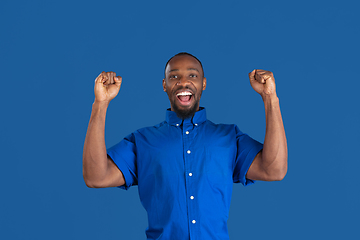 Image showing Monochrome portrait of young african-american man on blue studio background