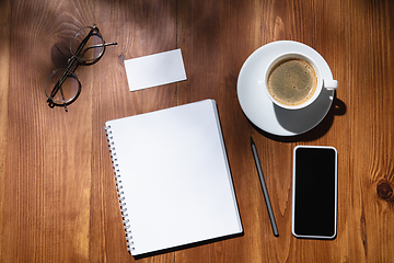 Image showing Creative and cozy workplace at home office, inspirational mock up with plant shadows on table surface