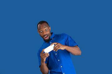 Image showing Monochrome portrait of young african-american man on blue studio background