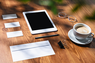 Image showing Creative and cozy workplace at home office, inspirational mock up with plant shadows on table surface