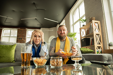 Image showing Excited family watching football, sport match at home, beautiful couple