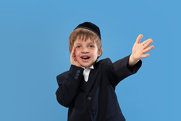 Image showing Portrait of a young orthodox jewish boy isolated on blue studio background, meeting the Passover