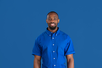 Image showing Monochrome portrait of young african-american man on blue studio background