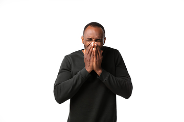 Image showing How coronavirus changed our lives. Young man sneezing on white background