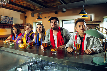 Image showing Sport fans cheering at bar, pub and drinking beer while championship, competition is going