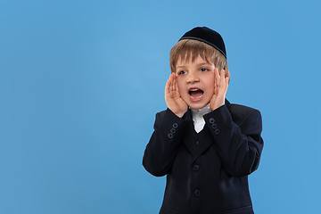 Image showing Portrait of a young orthodox jewish boy isolated on blue studio background, meeting the Passover