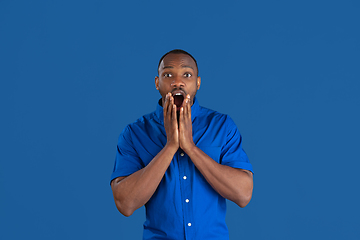 Image showing Monochrome portrait of young african-american man on blue studio background