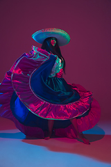 Image showing Fabulous Cinco de Mayo female dancer on purple studio background in neon light