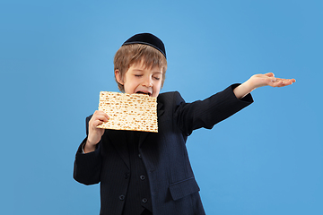 Image showing Portrait of a young orthodox jewish boy isolated on blue studio background, meeting the Passover