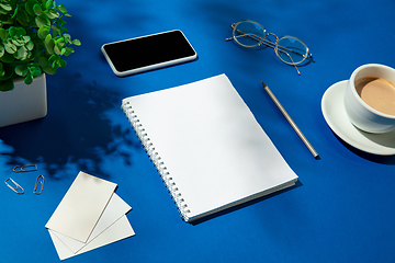 Image showing Creative and cozy workplace at home office, inspirational mock up with plant shadows on table surface