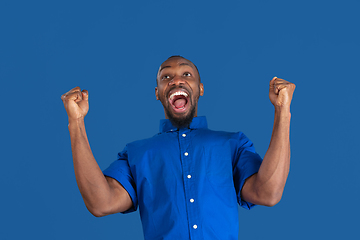 Image showing Monochrome portrait of young african-american man on blue studio background