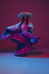 Image showing Fabulous Cinco de Mayo female dancer on purple studio background in neon light