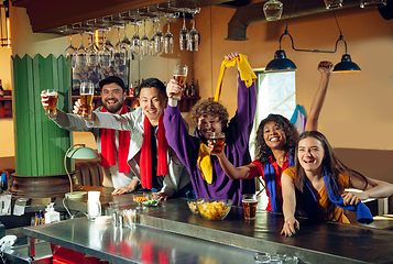 Image showing Sport fans cheering at bar, pub and drinking beer while championship, competition is going