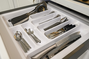 Image showing Open drawer with cutlery at modern white woden kitchen in classic style