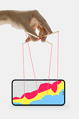 Image showing Businessman keeping the growth in economy, manipulating graphs like puppet