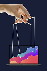 Image showing Businessman keeping the growth in economy, manipulating graphs like puppet