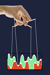 Image showing Businessman keeping the growth in economy, manipulating graphs like puppet