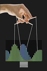 Image showing Businessman keeping the growth in economy, manipulating graphs like puppet