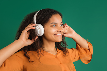 Image showing African-american woman portrait isolated on green studio background with copyspace