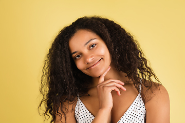 Image showing African-american woman portrait isolated on yellow studio background with copyspace