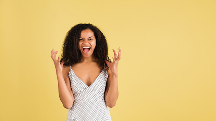 Image showing African-american woman portrait isolated on yellow studio background with copyspace