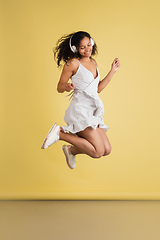 Image showing African-american woman portrait isolated on yellow studio background with copyspace