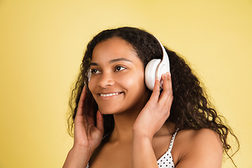 Image showing African-american woman portrait isolated on yellow studio background with copyspace