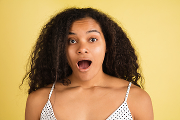 Image showing African-american woman portrait isolated on yellow studio background with copyspace