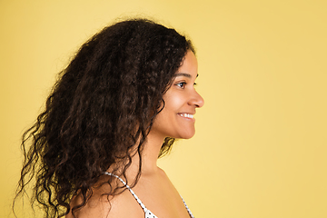 Image showing African-american woman portrait isolated on yellow studio background with copyspace