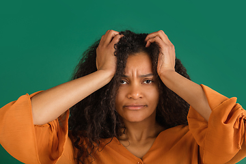 Image showing African-american woman portrait isolated on green studio background with copyspace