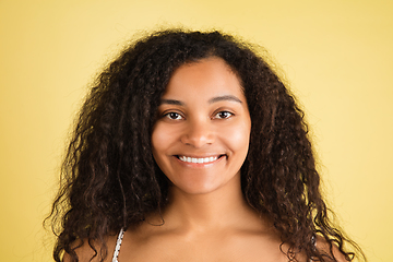 Image showing African-american woman portrait isolated on yellow studio background with copyspace