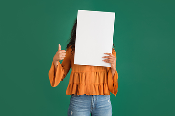 Image showing African-american woman portrait isolated on green studio background with copyspace