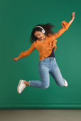 Image showing African-american woman portrait isolated on green studio background with copyspace