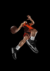 Image showing Young professional basketball player in action, motion isolated on black background, look from the bottom. Concept of sport, movement, energy and dynamic.