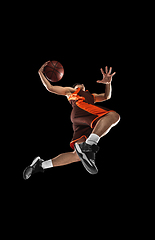 Image showing Young professional basketball player in action, motion isolated on black background, look from the bottom. Concept of sport, movement, energy and dynamic.