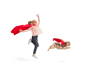 Image showing Child pretending to be a superhero with her super dog isolated on white studio background