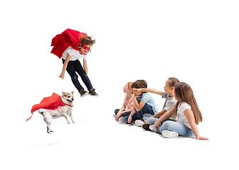 Image showing Child pretending to be a superhero with his super dog and friends sitting around