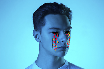 Image showing Tears illustrated of social media activity signs on male face in neon light. Real life versus online lifestyle, addiction to modern technologies